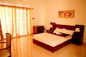 a bedroom with a bed and a large window at RJ Mahaal Hotel in Kilinochchi +22 photos