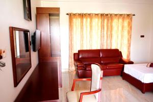 a living room with a couch and a bed at RJ Mahaal Hotel in Kilinochchi