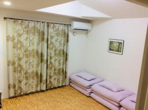 una sala de estar con taburetes rosas en una habitación en CASA HORIZONTE en Hachioji