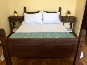 a wooden bed with two nightstands and two lamps at Hospedaje “ El Segoviano “ in Carmelo