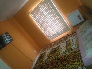 um quarto com uma cama e uma janela com uma cortina em Quartos da lagoa em Cabo Frio