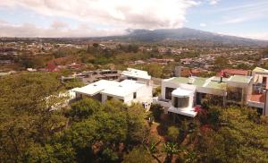 une vue aérienne sur une maison blanche dans une ville dans l'établissement Casa Marlui-San José, à Curridabat