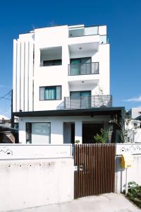 a white building with a fence in front of it at Easy Life B&B in Taitung City