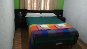 a bedroom with a colorful bed with towels on it at Casa La Norma in Nueva Palmira