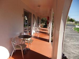 a balcony of a house with chairs and a table at Casa Mexicana in Paeroa