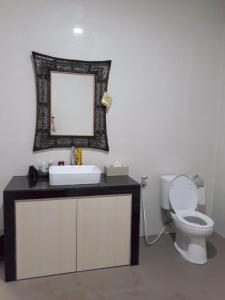 a bathroom with a sink and a toilet and a mirror at Jakson Homestay in Batam Center