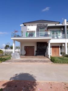 a large white house with a large driveway at Jakson Homestay in Batam Center