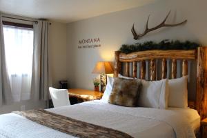 a bedroom with a bed and a desk with a table at The Evergreen in West Yellowstone