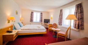 Postel nebo postele na pokoji v ubytování Hotel Heilquelle-Leukerbad-Therme + 37 fotografií