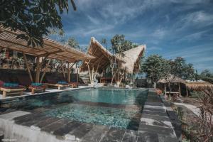 a pool at a resort with chairs and umbrellas at Menjangan Hill in Banyuwedang
