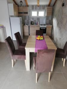 a wooden table with chairs and a bowl of fruit on it at Apartment Marija in Kotor