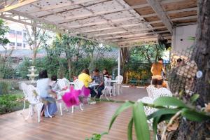 eine Gruppe von Personen, die auf einer Terrasse auf Stühlen sitzen in der Unterkunft Rak Kun Resort 2 in Nakhon Sawan