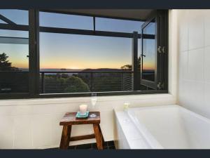 卡頓巴的住宿－Narrow Neck Views - Peaceful 4 Bedroom Home with Stunning Views!，带浴缸的浴室以及带蜡烛的桌子。