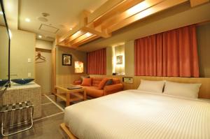een slaapkamer met een bed en een woonkamer bij Hotel Mid In Kawasaki Ekimae in Kawasaki