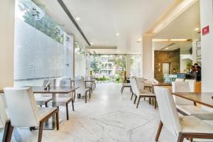 a dining room with tables and white chairs at FabHotel Prime Sage in New Delhi