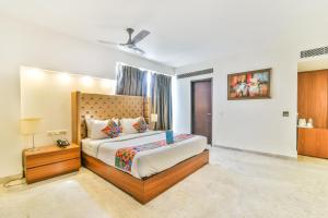 a bedroom with a large bed with a wooden headboard at FabHotel Prime Sage in New Delhi
