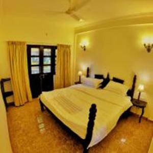 a bedroom with a large bed and a window at Feliz Arambol in Arambol