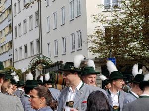 Un gruppo di uomini con il cappello in piedi in mezzo alla folla di Hotel Der Tannenbaum a Monaco