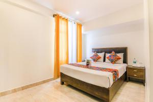 um quarto com uma cama grande e uma mesa de cabeceira em FabHotel Oakwey Inn Indiranagar em Bangalore