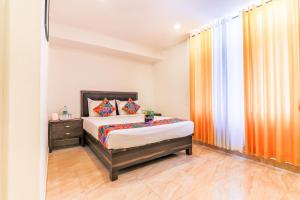 a small bedroom with a bed and a window at FabHotel Oakwey Inn - Indiranagar in Bengaluru