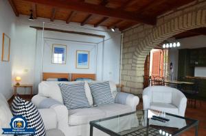 a living room with a white couch and a glass table at Finca La Tosca in Guía de Isora