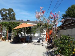 a patio with an orange umbrella in front of a house at OC House in Santa Ana