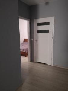 een lege kamer met een deur naar een slaapkamer bij Apartament Południowy in Radom