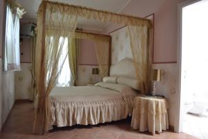 a bedroom with a canopy bed with a window at La Tenuta Del Giglio in Tavullia