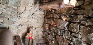 un mur en pierre avec des bougies devant un mur dans l'établissement U paliaghju, une cabane de berger pour vivre un dépaysement total, à Santa-Lucia-di-Mercurio
