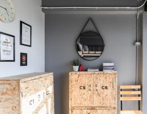 een kamer met een spiegel en een houten kast bij Jeune Hostel Chiang Mai - Chang Phuak in Chiang Mai
