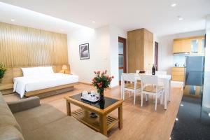 a hotel room with a bed and a living room at Canary Ha Noi Hotel in Hanoi