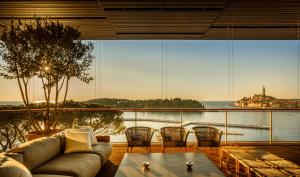 a living room filled with furniture next to a river at Grand Park Hotel Rovinj by Maistra Collection in Rovinj