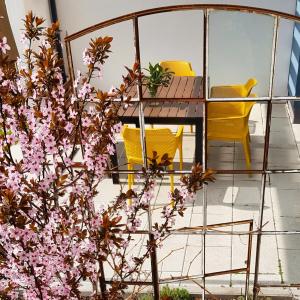 a table and chairs on a balcony with pink flowers at ElbQuartier Apartments Magdeburg 'Die Stadtoase' in Magdeburg