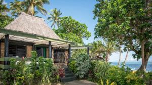 a house on the beach with the ocean in the background at Crusoe's Retreat - Family Friendly in Namanggumanggua