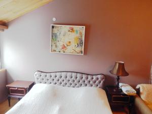 a bedroom with a bed and a picture on the wall at When in Tbilisi in Tbilisi City