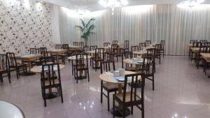 una sala da pranzo con tavoli, sedie e tende di ACasaMia WelcHome Hotel a Rimini