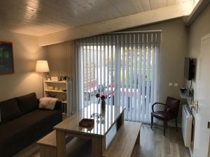 a living room with a couch and a table at Les Terrasses de La Malcombe in Besançon