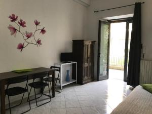 uma sala de estar com uma mesa e uma mesa de jantar com uma parede de flores em Loft Regio Parco em Turim