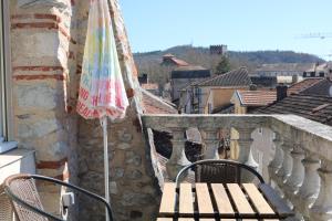 um guarda-chuva e um banco numa varanda em Maison Cahors em Cahors