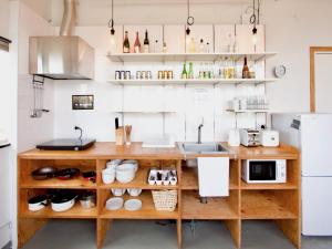 a kitchen with wooden shelves and a counter at Ishigaki Guesthouse HIVE in Ishigaki Island