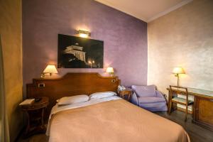 a hotel room with a bed and a chair at Hotel Kent in Rome
