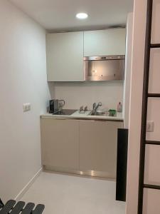 a kitchen with white cabinets and a sink at STUDIO MARCHE PROVENCAL in Antibes