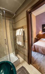 a bathroom with a shower and a bed in a room at Hotel Kent in Rome