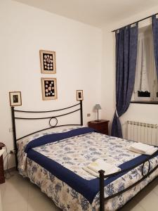 a bedroom with a bed with blue sheets and a window at Terre Apartment in Corniglia