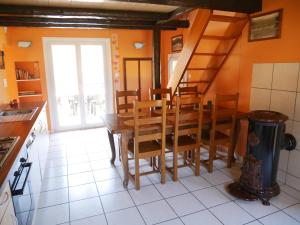 een keuken met een tafel en stoelen en een trap bij Chalet pour amoureux de la nature avec vue sur le lac de Retournemer in Xonrupt-Longemer +54 foto's