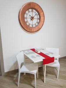 a white table with a clock on a wall at Residenza Lumière in Termoli