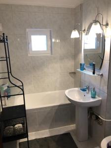 La salle de bains est pourvue d'un lavabo et d'une baignoire. dans l'établissement Blue Apartment, à Drobeta-Turnu Severin