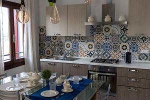 uma cozinha com uma mesa e um fogão forno superior em La Casa di Bassano em Bassano del Grappa