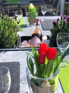 uma mesa com uma garrafa de vinho e flores em Hotel Angelo em Saarbrücken