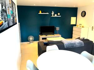 a living room with a couch and a tv at T2 Moderne avec jardin in Rayol-Canadel-sur-Mer